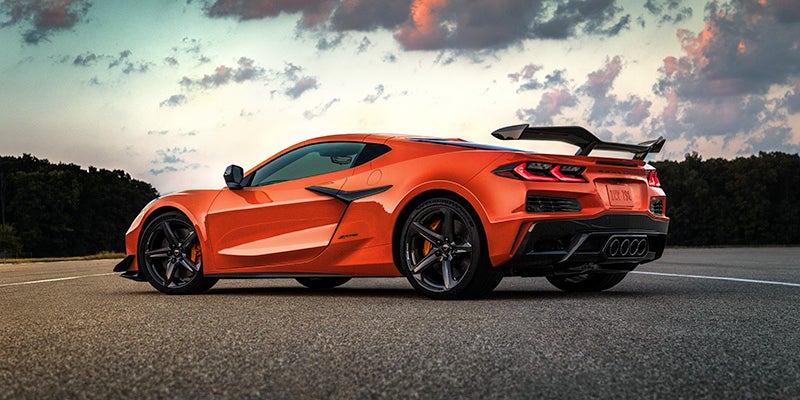 An orange Chevrolet Corvette Z06 parked on an open road at sunset