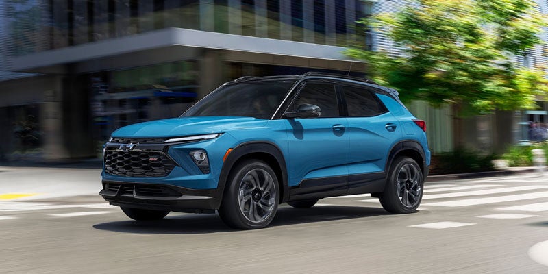 A blue Chevrolet Trailblazer driving through a city intersection